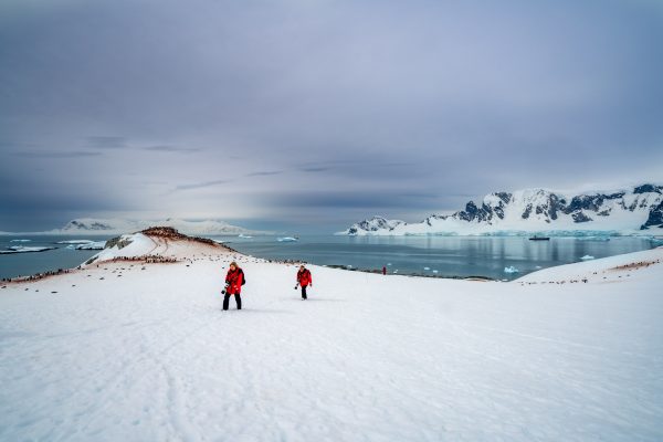 Two photographers in red jackets exploring on the Antarctic Peninsula