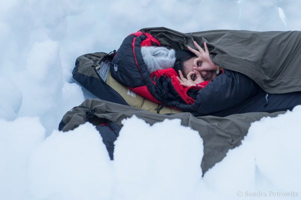 A traveller in a bivvy bag in the snow on the Antarctic Peninsula
