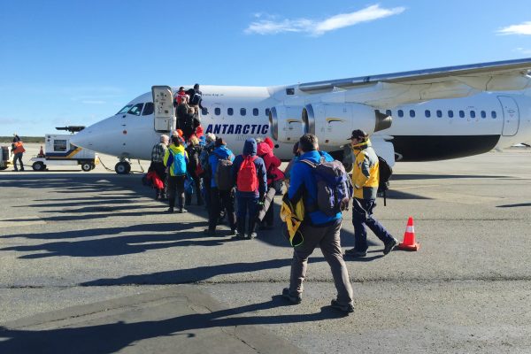 A small aircraft on the tarmac with adventure travellers boarding
